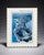intage-style Puerto Rico wall art featuring a blue-toned aerial coastal city view. The piece shows an oceanfront cityscape...