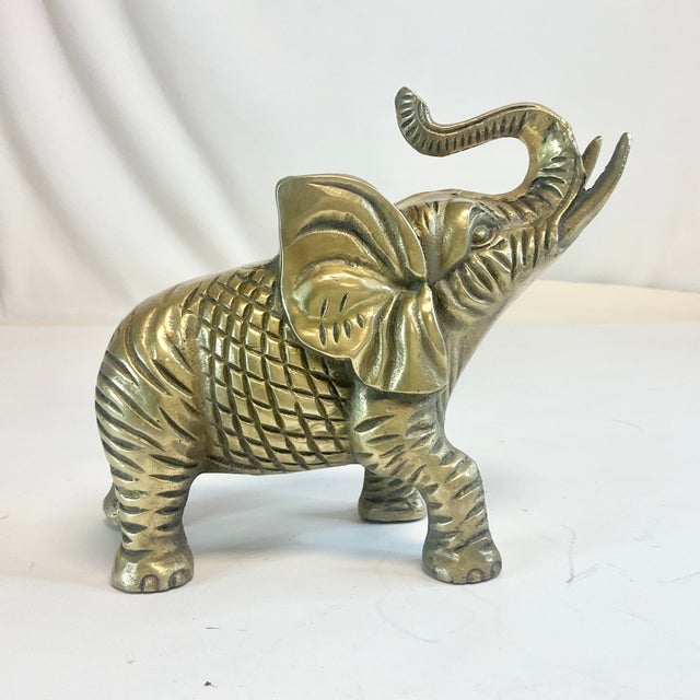 This is a very heavy, solid Brass Elephant from the Mid-Century. The figurine is highly detailed with an etched criss-...