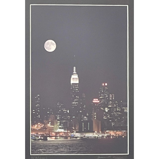 Atmospheric skyline photo showing the Empire State Building and iconic New Yorker Hotel under a full moon. 2006 photo...