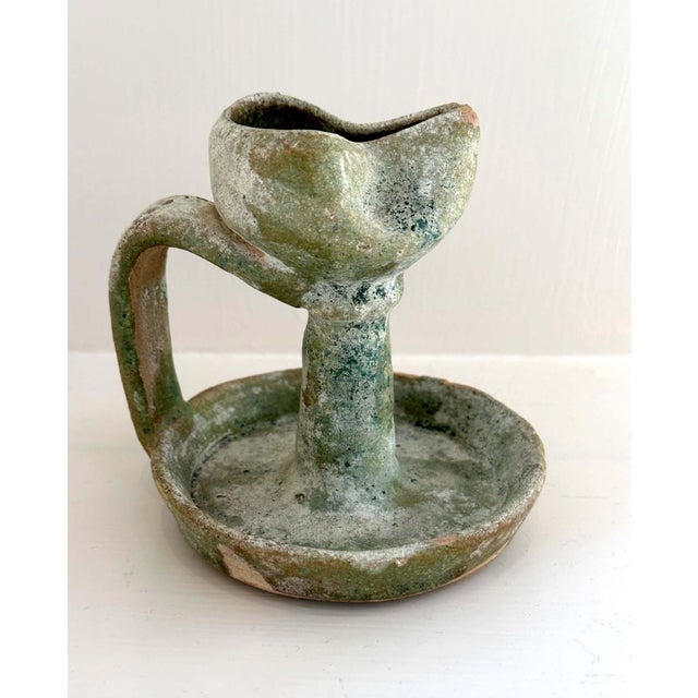 A collection of four Early Persian Glazed Pottery Oil Lamps from an American collection. It consists of three oil lamps...