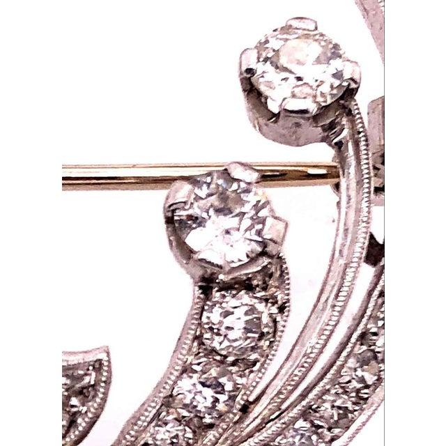 14 Karat White Gold Vintage Diamond Circle Pin / Brooch having a floral design set with a large .60 round diamond of...