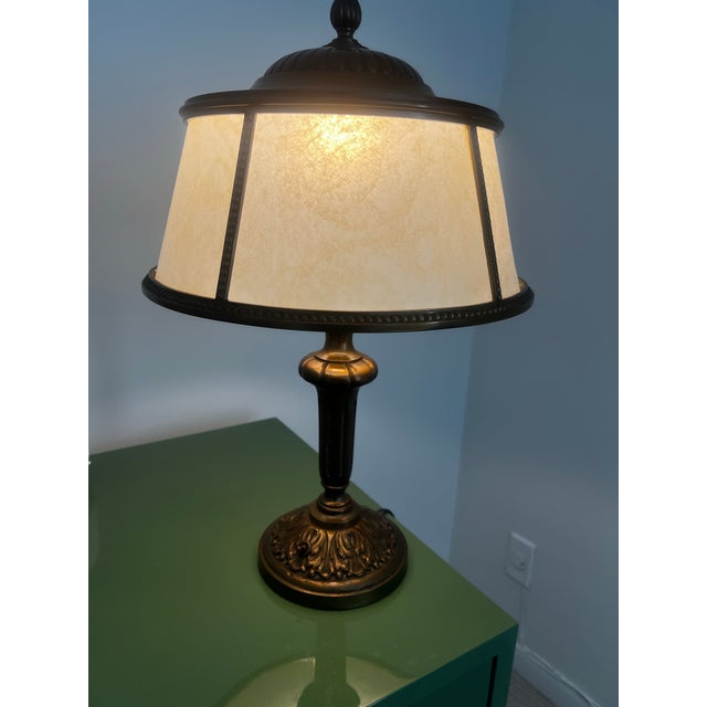 Elegant neoclassical bronze table lamp, circa 1930s, featuring its original vellum shade with beautifully aged patina and...
