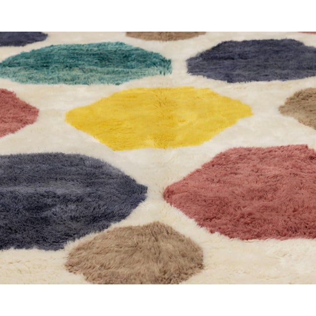 Vibrant hand-knotted wool rug featuring a mosaic of multicolored polygons in shades of Luminous Yellow, Emerald Green,...