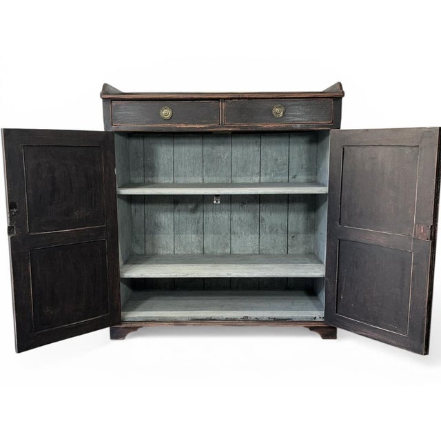 Antique Gustavian Sideboard in deep black. On the edge of the tabletop, on three sides, there is a wooden frame. In the...