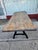 Rustic dining table has a thick solid wood top with a distressed blue and brown finish. The base consists of two heavy-...