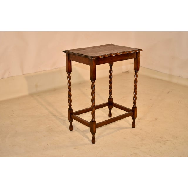 Circa 1900 Period Edwardian oak side table from England. The top has a scalloped and beveled edge, following down to a...