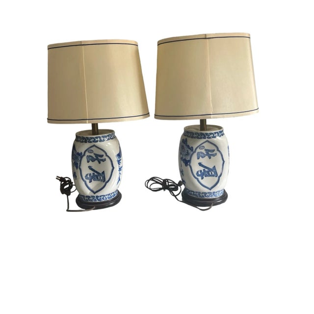 A pair of Chinese porcelain blue and white opium pillow lamps with calligraphy and foliate decoration resting on carved...
