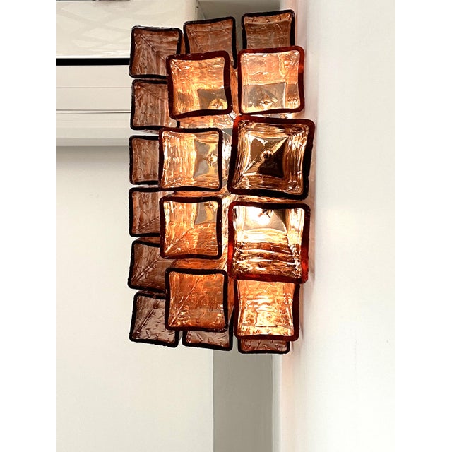 Elegant contemporary wall sconces made in amber-Rosè Murano glass “squared” elements. “Squared ” are blown inside a wooden...