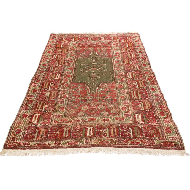 Originating from Turkey in 1890, this antique traditional Gordes wool rug features a medallion style field design and a...