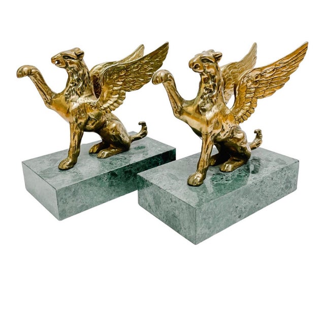 A fantastic pair of 1970s solid brass griffins on green marble bases. These are substantial in size and weight, each...