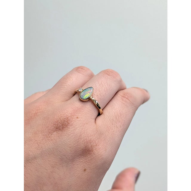 This handcrafted 14K yellow gold ring showcases a striking boulder opal, alive with natural color play. The asymmetrical...