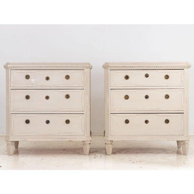 This charming pair of Gustavian-style chests of drawers exudes timeless Swedish elegance. Bathed in a soothing greige...