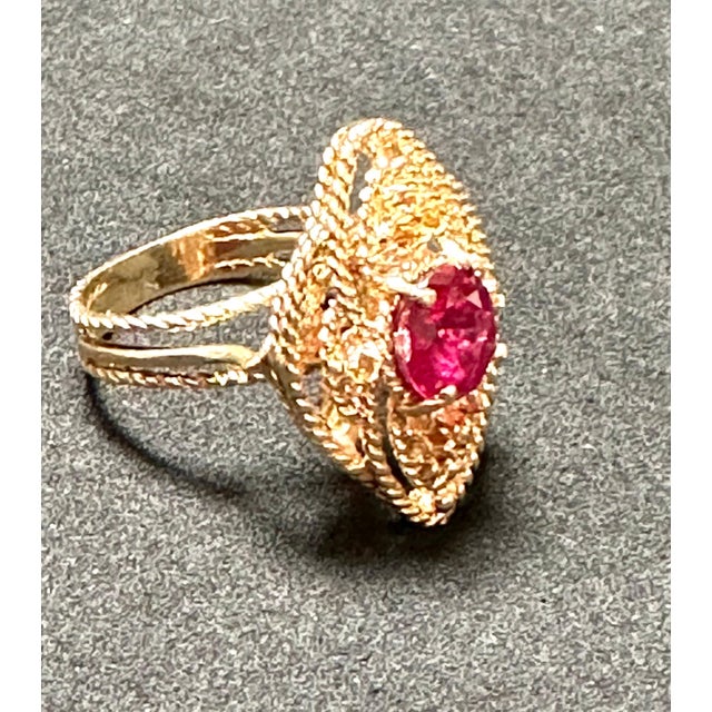 Introducing our exquisite Vintage 14 Karat Yellow Gold Cocktail Ring featuring a stunning 2 carat treated round ruby. This...