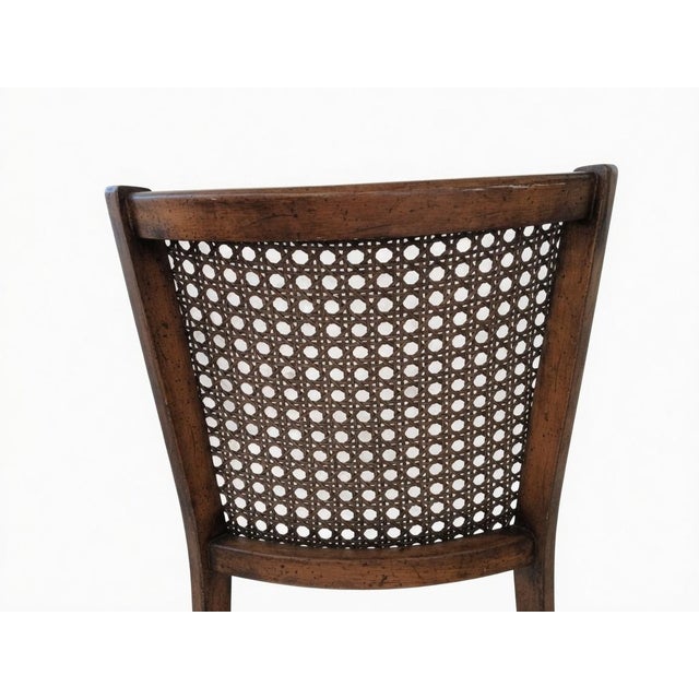 Beautiful vintage cane back armchair with a classic solid wood frame and soft floral upholstery. This charming accent...