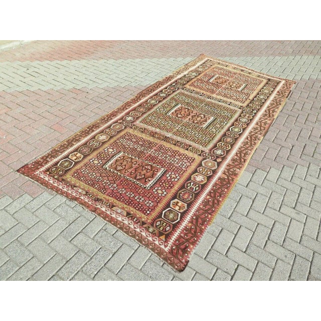 This beautiful, traditional vintage, flatweaved Turkish kilim rug is approximately 90 years old. It is handmade of very...