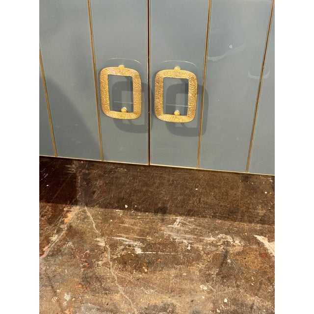 This Italian Modernist Glass and Brass Sideboard is a stylish and functional addition to any living room. Made of elegant...