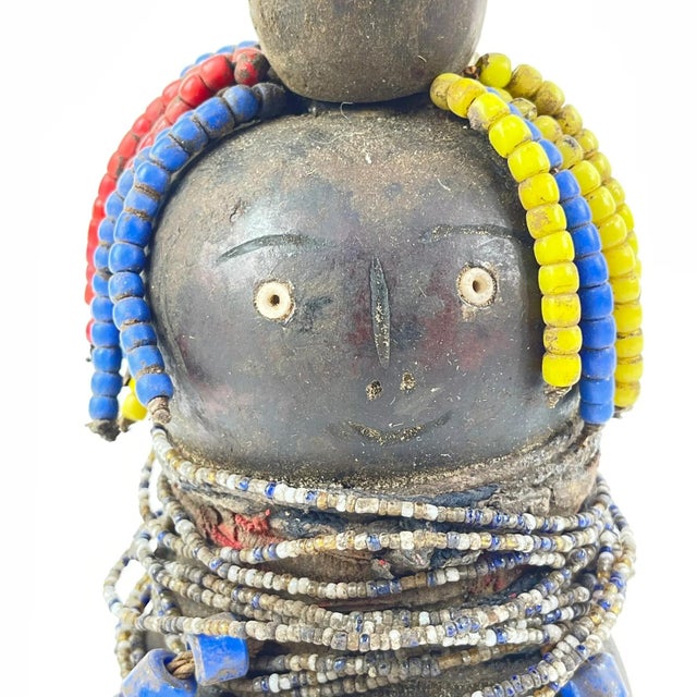 The Nyamwezi Beaded Fertility Doll Gourd with Shells from Tanzania is a stunning representation of fertility and...