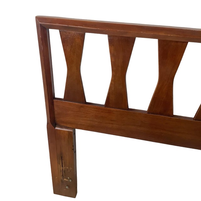 This mid-century headboard stands out for its row of sculptural, hourglass-shaped spindles spanning the top rail — a...
