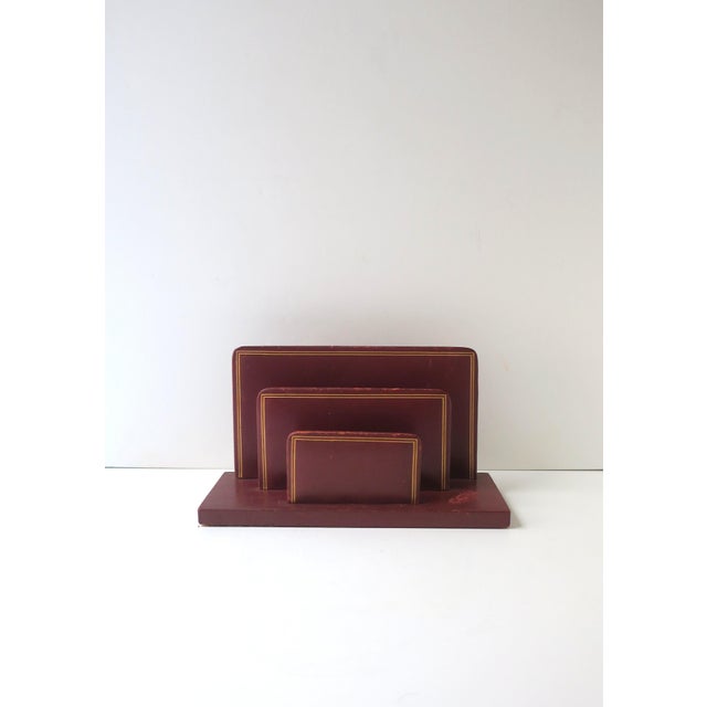 A French red‑burgundy leather letter holder with gold‑tooled trim, in the style of luxury maison Cartier, Classic /...
