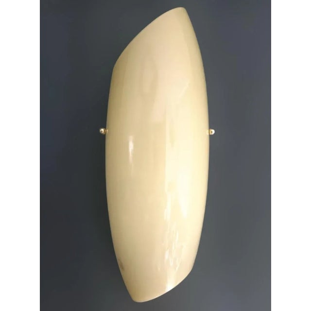 Italian wall light with creamy yellow Murano glass shade in the shape of shell, mounted on white metal frame / Made in...