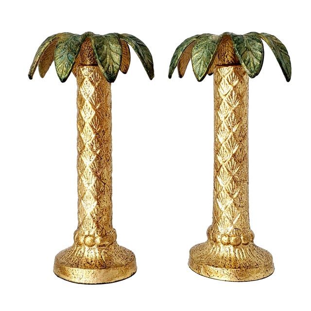 Offering a pair of vintage gold leaf metal palm tree candlesticks, circa 1970s. The candlesticks are made of a very heavy...