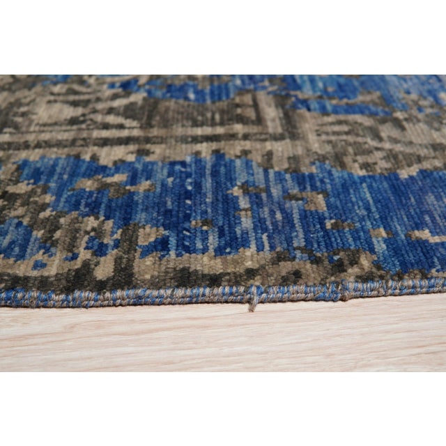 A hand-knotted wool rug, made in India and measuring 8' x 10'. Floral drawing carried across the field inside a...