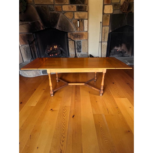 Bring timeless mid-century craftsmanship into your home with this stunning 1970s Ethan Allen solid maple draw-leaf dining...