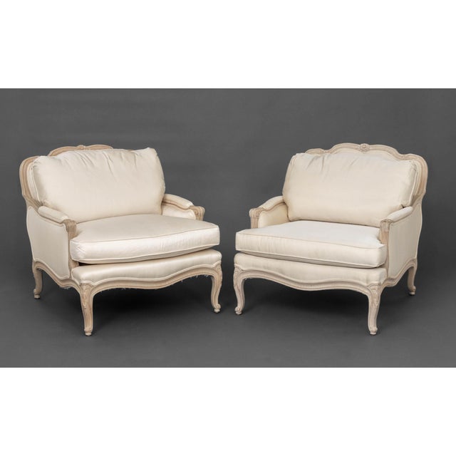 Pair of Louis XV Style White Fabric Upholstered Cerused Wood Bergeres, with Interior Crafts labels beneath cushions....