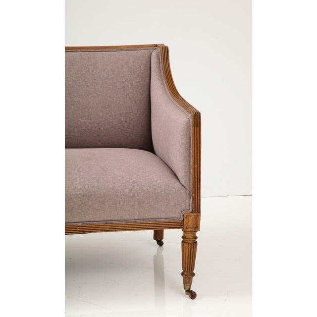 Experience the elegance of the English Regency era with this exquisite early 19th-century fruitwood square back loveseat....