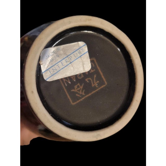 A pair of glossy black floral peacock porcelain vases. The vases feature a glossy black background with peacocks and...