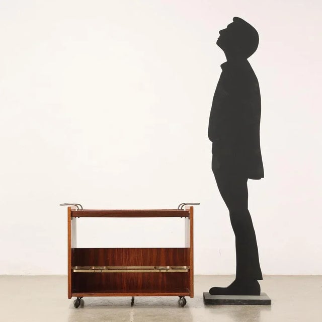 Service trolley; exotic wood veneer, formica, brass. This piece is attributed to the mentioned designer/maker. It has no...