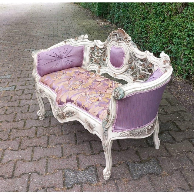 A charming vintage French Louis XVI style settee dating from the 1970s, beautifully handcrafted from carved beechwood with...