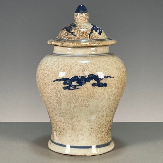 A charming Chinese blue and white porcelain covered jar featuring a heavy, all-over crackle glaze. The jar has a classic...