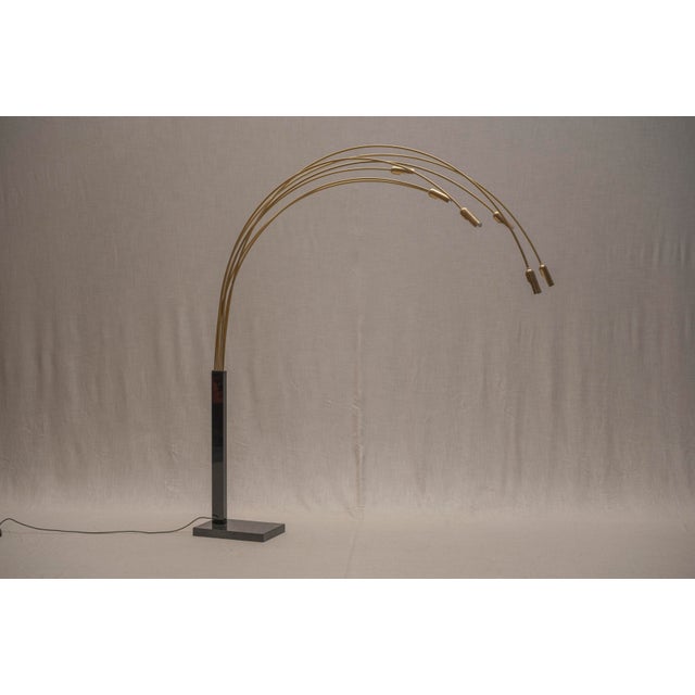 Striking floor lamp from the 1970s, featuring an impressive arrangement of slender, arching arms in gilded metal, rising...