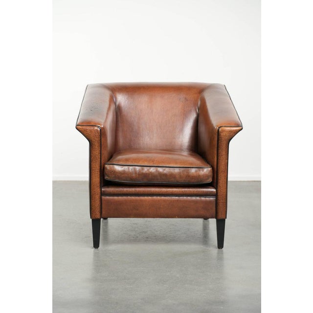 This beautiful, sleek Art Deco-style armchair / fauteuil in sheepskin leather features black piping and a rich warm...