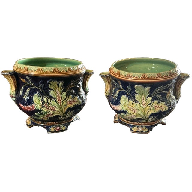 Beautiful pair of Belgian majolica cache pots. They feature Art Noveau design elements, characterized by floral motifs and...