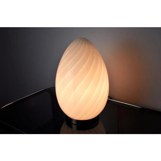 Very nice table lamp designated and produced in Spain in the 1970s. Egg-shaped blown glass, golden metal base. Unique...