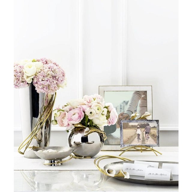 Small contemporary silver and gold metal calla lily vase designed as a decorative and functional object. This small vase...