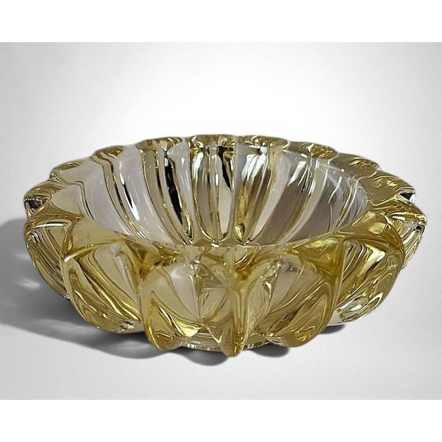 Elegant and iconic molded yellow glass bowl, distinguished by its clean, well-balanced form, the result of the refined...
