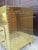 A striking pair of vintage Hollywood Regency-style three-drawer nightstands featuring brass-tone metal cladding,...