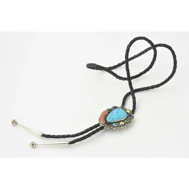 Great Native American Bolo retailed at Silver Cloud Jewelrywith large turquoise center surrounded in a frame with rope...