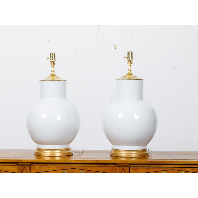 A pair of Asian porcelain ginger jars mounted as table lamps and wired for the USA. This pair of lamps exudes timeless...