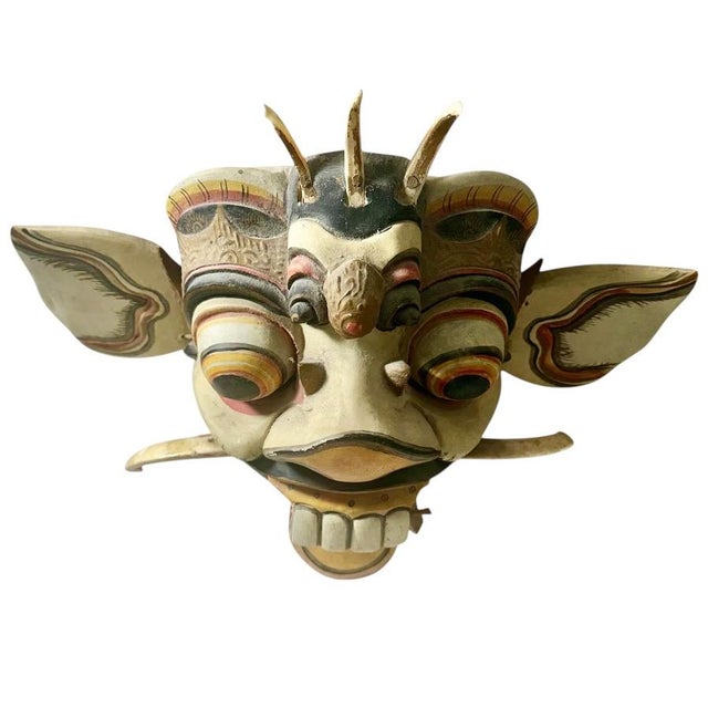 Balinese carved wood deity mask, circa 1950s. Highly decorated and hand-carved from wood, this expressive mask features...