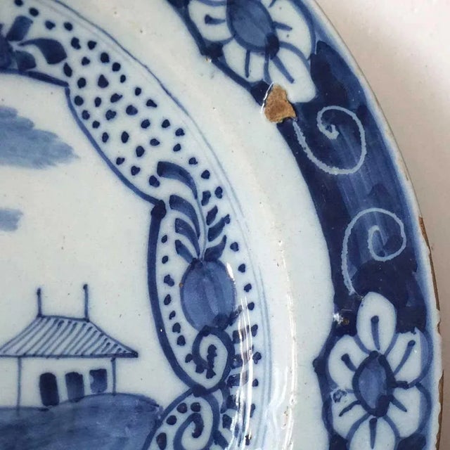 This large, antique Dutch pottery low bowl is painted in the Chinese Export style. DATE 18th century