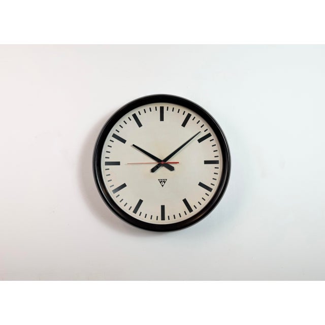 This large wall clock was produced by Pragotron in former Czechoslovakia during the 1960s. It features a brown bakelite...