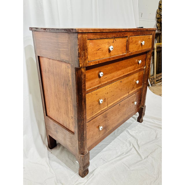 A charming antique American Sheraton/Empire cottage chest crafted in warm cherry wood, featuring a clean, balanced...