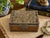 Vintage Chinese decorative box crafted with warm wood panels and an intricately detailed silver-tone dragon overlay. The...