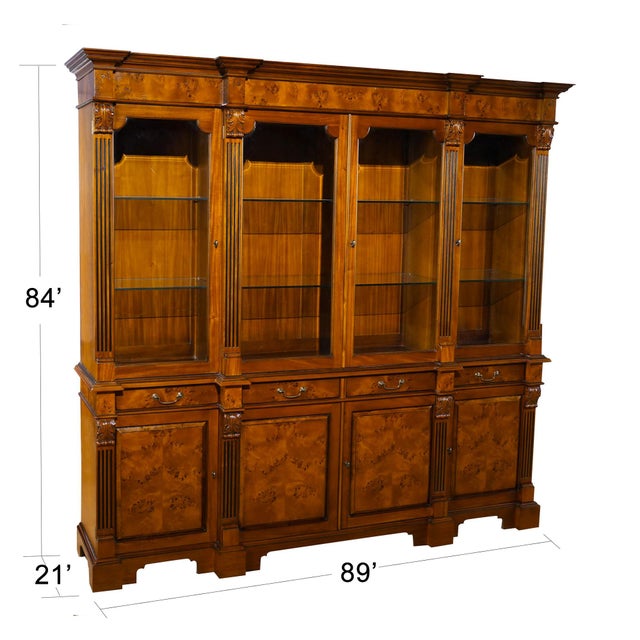 Our Burled Breakfront is manufactured in two sections, the upper section consisting of a deep, molded cornice with burled...