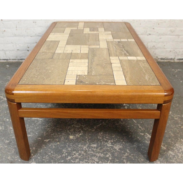 This teak and tile coffee table was handcrafted by Haslev in Denmark. The table top feature an offset tiled grid, while...