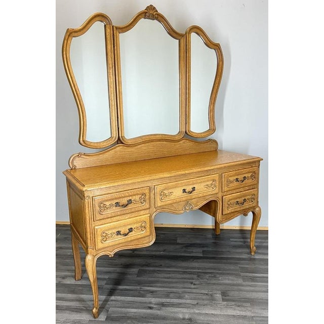 This Vintage French Louis dressing table presents a beautifully refined silhouette with elegant carved detailing and a...